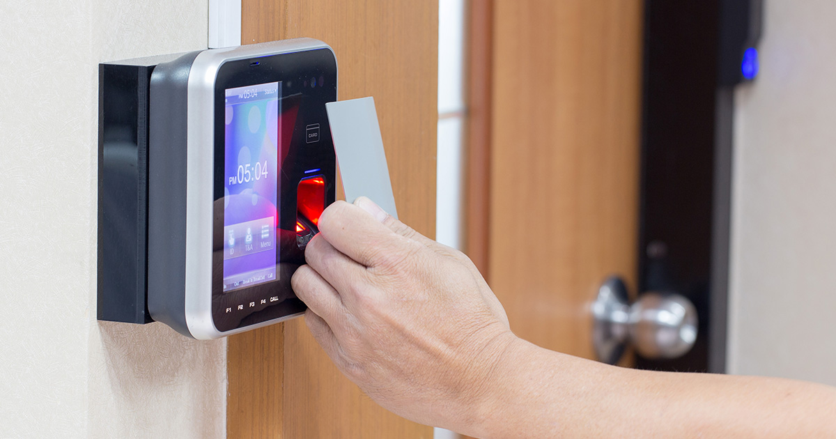 Hand holding ID card to door access panel